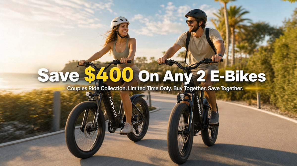 Two people riding electric bicycles on a sunny coastal road, with large promotional text overlay reading 'Save $400 On Any 2 E-Bikes' and smaller text about the Couples Ride Collection.