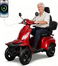 A red and black four-wheeled electric mobility scooter with a smiling older man sitting on it, shown on a white studio background. A smartphone graphic at the upper left shows a charging connection.